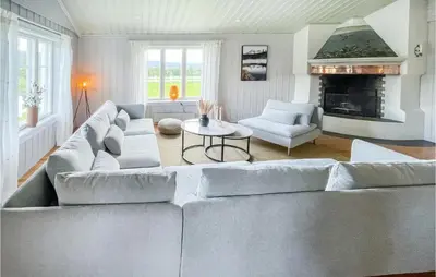 a living room with a large couch and a fireplace at Lovely Home In Koppang With Kitchen in Koppang