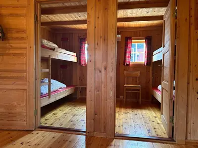 a room with two bunk beds in a log cabin at Atnasjø Kafe AS in Sollia
