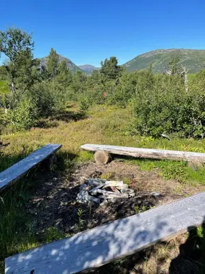 a bench sitting on top of a hill with a fire at Solsetra - Mountain Majesty Family Log Cabin in Hovden