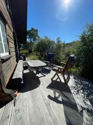 a wooden deck with a picnic table and a bench at Solsetra - Mountain Majesty Family Log Cabin in Hovden