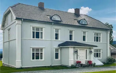 a white house with a gambrel roof at Gorgeous Home In Koppang With Sauna in Koppang