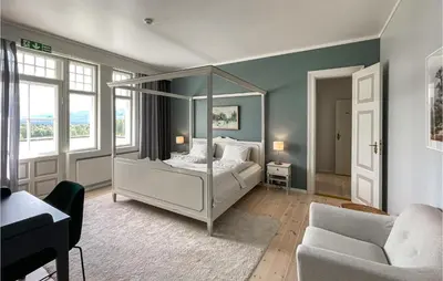 a bedroom with a canopy bed and a couch at Gorgeous Home In Koppang With Sauna in Koppang