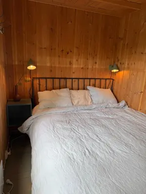 a bedroom with a large bed with wooden walls at River view in Hovet