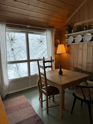 a table and chairs in a room with a window at River view in Hovet