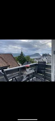 a balcony with a table and chairs on a roof at Leilighet med sydvendt balkong in Ålesund