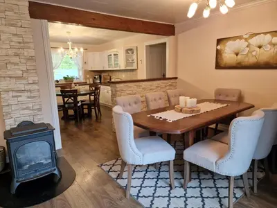 a dining room with a table and a wood stove at Mountain & Fjord View Apartment in Stryn