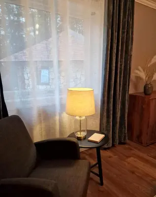 a lamp sitting on a table in front of a window at Mountain & Fjord View Apartment in Stryn