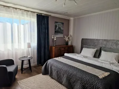 a bedroom with a bed and a chair and a window at Mountain & Fjord View Apartment in Stryn