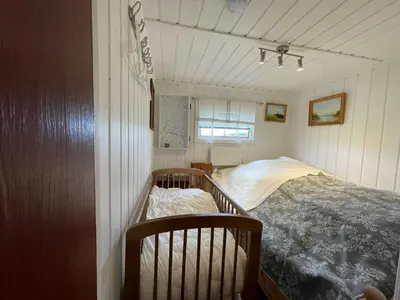 a small bedroom with a bed and a window at Snikkerplassen - cabin with amazing view and hiking opportunities in Sør-Fron