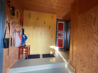 a room with a wooden wall with a chair in it at Elveseter - log cabin with an amazing view in Venabygd