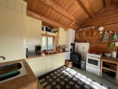 a kitchen with white appliances and wooden ceilings at Elveseter - log cabin with an amazing view in Venabygd