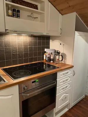 a kitchen with a stove and a counter top at Flott rorbu på idylliske Langevåg/Bømlo in Bømlo