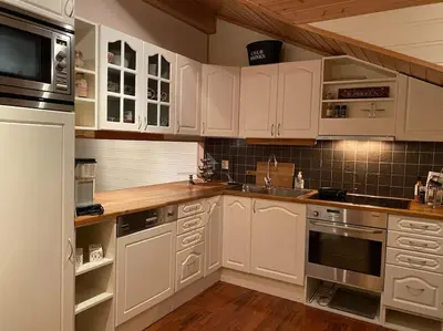 a kitchen with white cabinets and a counter top at Flott rorbu på idylliske Langevåg/Bømlo in Bømlo