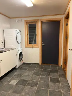 a kitchen with a black door and a microwave at Flott rorbu på idylliske Langevåg/Bømlo in Bømlo