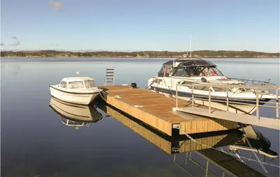 two boats are docked at a dock on the water at Stunning Home In Fitjar With Wifi in Fitjar