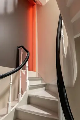 a set of stairs in a home with an orange wall at Dinbnb Apartments I New 2023 I 600m to Bryggen in Bergen