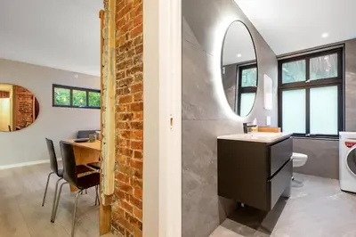 a bathroom with a sink and a brick wall at Dinbnb Apartments I New 2021 I Affordable Option in Bergen