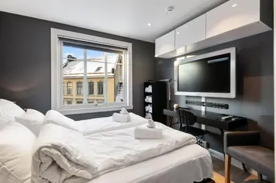 a bedroom with two beds and a flat screen tv at Dinbnb Homes I Historical 1850 House in Bergen