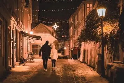 a man and woman walking down a street at night at Dinbnb Homes I Historical 1850 House in Bergen
