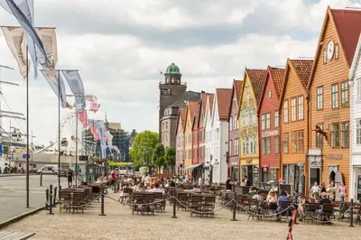 a city street with buildings and people sitting at tables at Dinbnb Homes I Historical 1850 House in Bergen