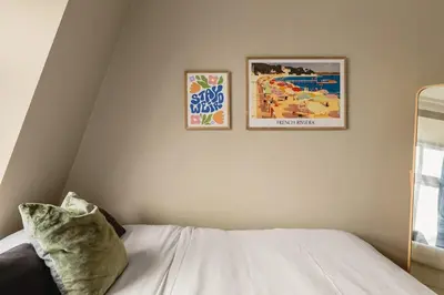 two posters on a wall above a bed in a room at Dinbnb Apartments I New 2021 I SONOS and SMART TV in Bergen