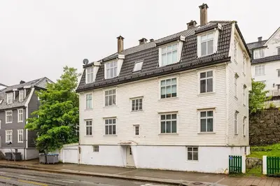 a large white building on the side of a street at Dinbnb Apartments I New 2021 I SONOS and SMART TV in Bergen