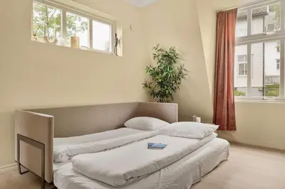 two beds in a room with two windows at Dinbnb Apartments I New 2021 I SONOS and SMART TV in Bergen