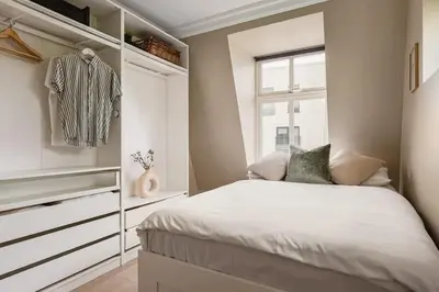a bedroom with a bed and a dresser and a window at Dinbnb Apartments I New 2021 I SONOS and SMART TV in Bergen
