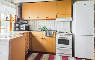 a kitchen with yellow cabinets and a white refrigerator at 3 Bedroom Lovely Home In Mosvik in Mosvik