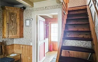 a wooden staircase in a room with a door at 3 Bedroom Lovely Home In Mosvik in Mosvik