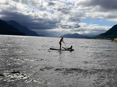 a person on a paddle board in the water at Nakkentunet - familievennlig hus på gårdstun. in Ørskog