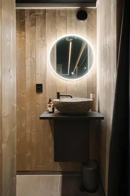a bathroom with a stone sink and a mirror at Hide Hut - Amazing view 50 min from Oslo in Stange