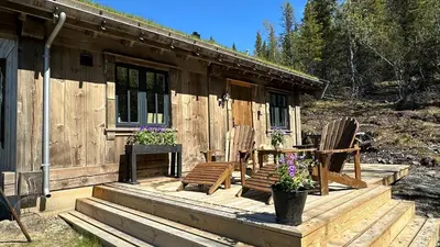 a cabin with two chairs and a table on a deck at Liaplassen Mountain Chalet - Beitostølen in Beitostøl