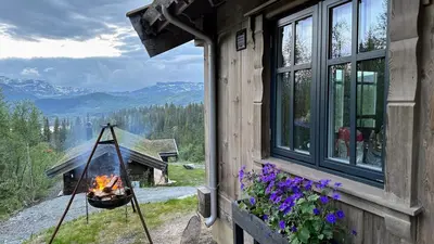 a fire pit on the side of a house at Liaplassen Mountain Chalet - Beitostølen in Beitostøl