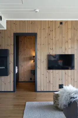 a living room with wooden walls and a flat screen tv at Spacious and modern apartment in the heart of Geilo, perfect year round! in Geilo