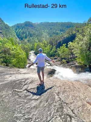 a man standing on a rock near a river at Apartment-A near Etne-Odda in Etnesjøen