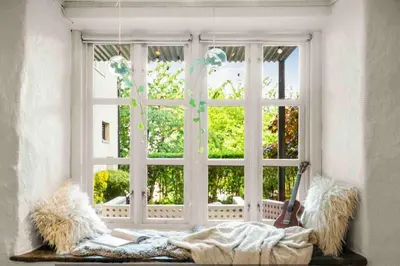 a woman laying on a blanket in front of a window at The old bakery in Sandviken in Bergen
