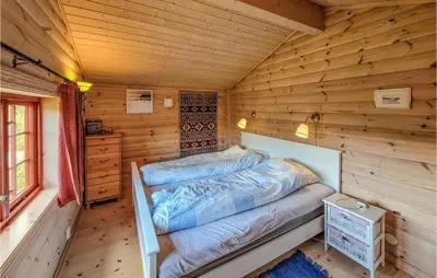 a bed in a cabin with wooden walls at 3 Bedroom Stunning Home In Vossestrand in Vossestrand