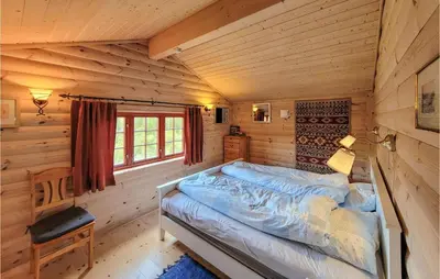 a bedroom with a bed in a log cabin at 3 Bedroom Stunning Home In Vossestrand in Vossestrand