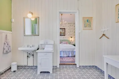 a bathroom with a sink and a bed at Visnes Hotel Stryn in Stryn