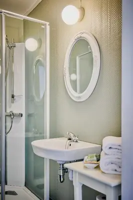 a bathroom with a sink and a shower and a mirror at Visnes Hotel Stryn in Stryn