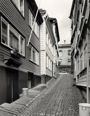 a black and white photo of a street with buildings at Dinbnb Apartments I Historical Two-Floor Apartment with Rooftop Panorama I 1645 Heritage in Bergen