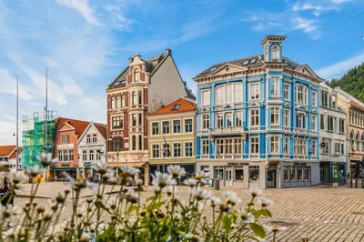 a group of buildings on a street with flowers at Dinbnb Apartments I Historical Two-Floor Apartment with Rooftop Panorama I 1645 Heritage in Bergen