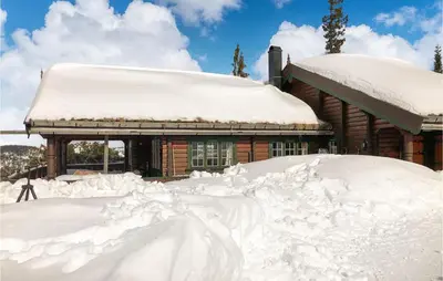 a house covered in snow in front of a building at Lovely Home In Veggli With Kitchen in Veggli