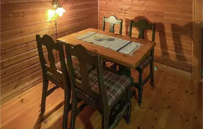 a wooden table and chairs in a room with wooden walls at Lovely Apartment In Trysil With Wifi in Trysil