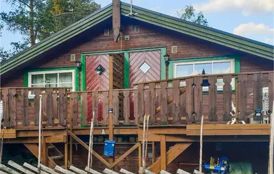 a log cabin with a deck and a fence at Lovely Apartment In Trysil With Wifi in Trysil