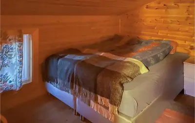 a bed in a log cabin with a window at Lovely Apartment In Trysil With Wifi in Trysil