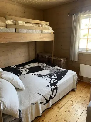 a bedroom with a bed in a log cabin at Osetunet, small and charming cabin at Ustaoset in Ustaoset