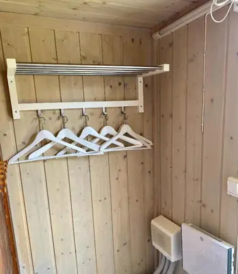 a bathroom with wooden walls and a closet with white shelves at Osetunet, small and charming cabin at Ustaoset in Ustaoset