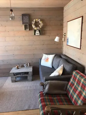 a living room with a couch and a table at Osetunet, small and charming cabin at Ustaoset in Ustaoset